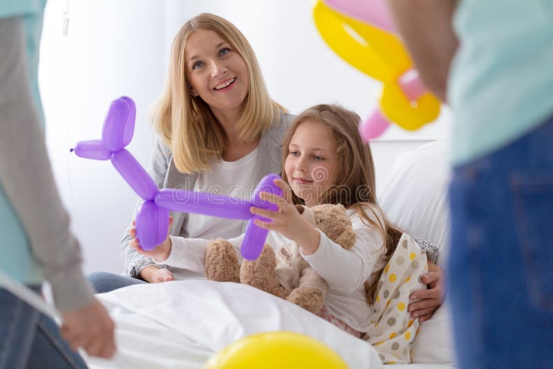 Ung volontär i sjukhuset som gör ungen lycklig royaltyfri bild Ung volontär i sjukhuset som gör ungen lycklig royaltyfri bild
