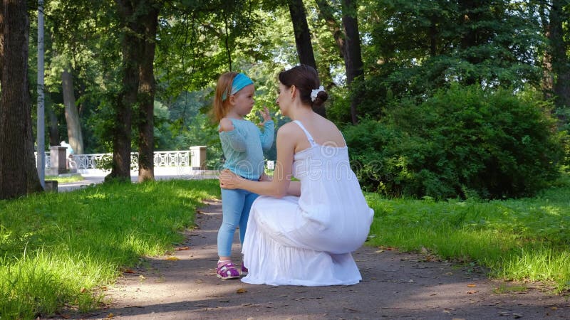 Ung vårdnadsmamma kommunicerar med sin charmerande lilla dotter lager videofilmer