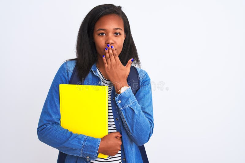 Unga afrikaner-studentkvinna som bär ryggsäck och bok över isolerad bakgrundshäck med hand chockad av skam arkivbilder
