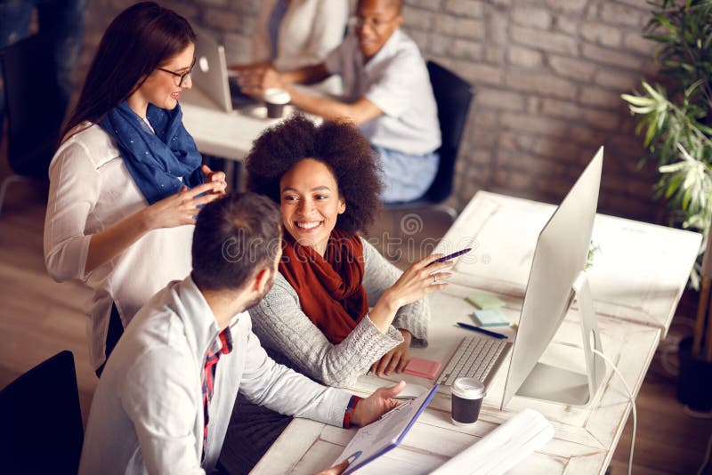 Group of young employees in office talking and working. Group of young employees in office talking and working