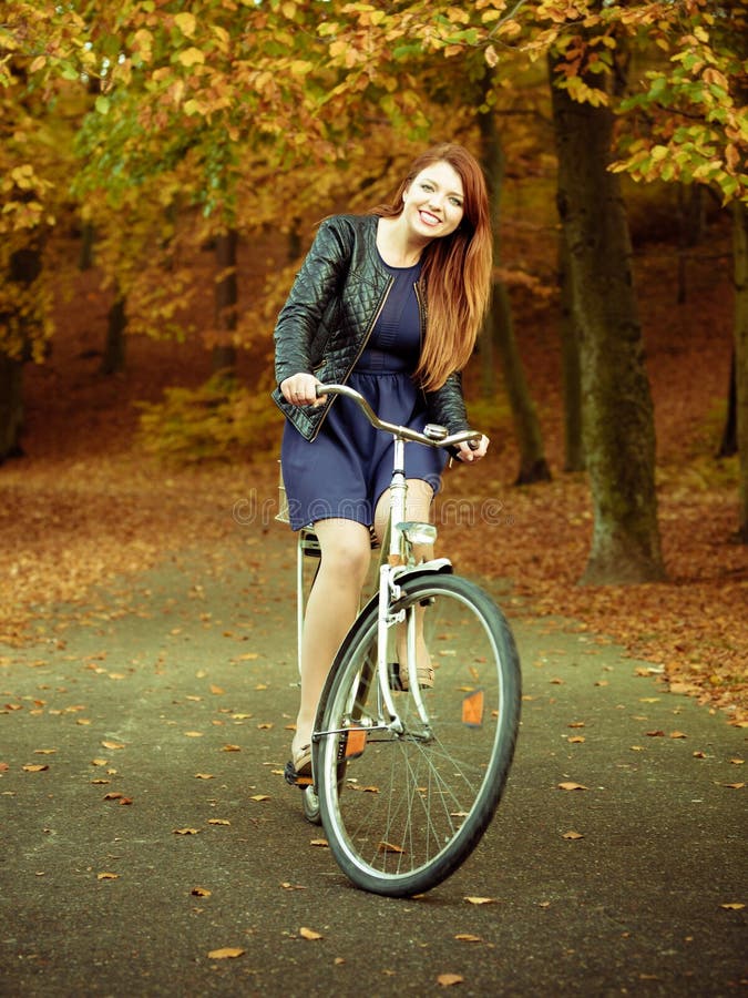 Unga flickan rider cykeln i parkera royaltyfri bild Unga flickan rider cykeln i parkera royaltyfri bild