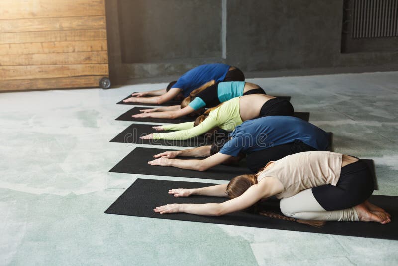Unga kvinnor och män i yoga klassificerar, kopplar av meditation poserar fotografering för bildbyråer Unga kvinnor och män i yoga klassificerar, kopplar av meditation poserar fotografering för bildbyråer