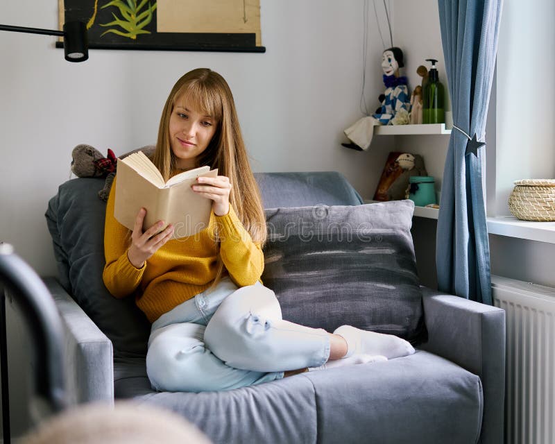 Woman sitting on couch and reading book. Social media detox. Slow living lifestyle. Mental wellbeing on quarantine. Happy female enjoying literature. Calm bookworm spending day off gadgets. Woman sitting on couch and reading book. Social media detox. Slow living lifestyle. Mental wellbeing on quarantine. Happy female enjoying literature. Calm bookworm spending day off gadgets