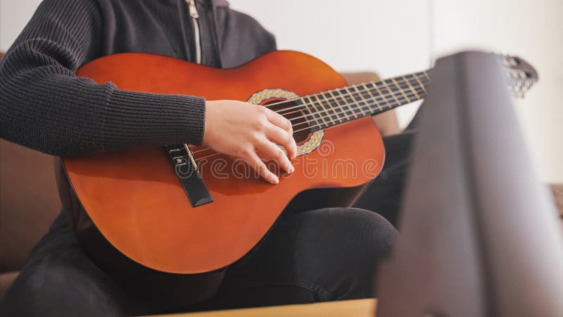 Unga musiker spelar akustisk gitarr hemma arkivfoton