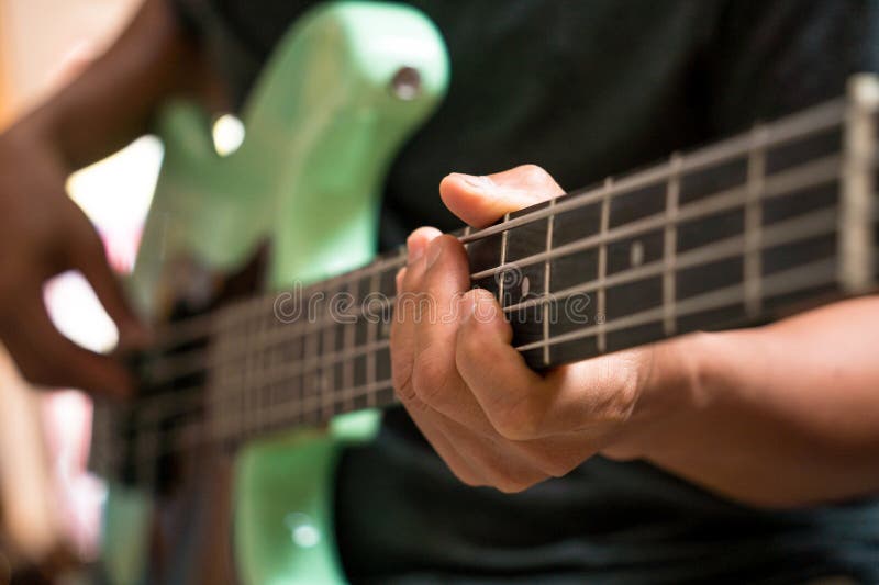 Unga musiker testar basgitarr i en gitarbutik.