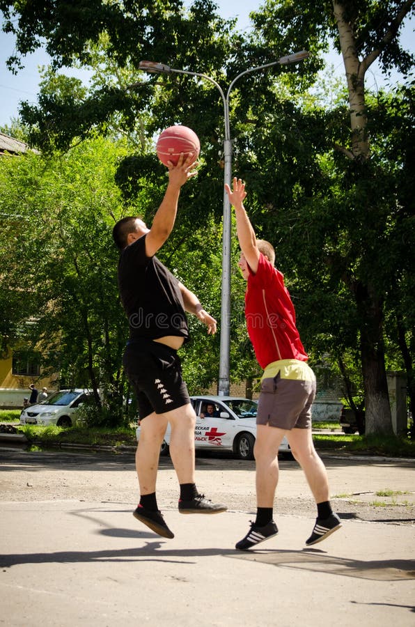 Unga män spelar amatörmässig basket i sommar Låg punktskytte fotografering för bildbyråer Unga män spelar amatörmässig basket i sommar Låg punktskytte fotografering för bildbyråer
