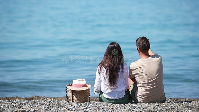 Unga par på vit strand under sommarsemestern