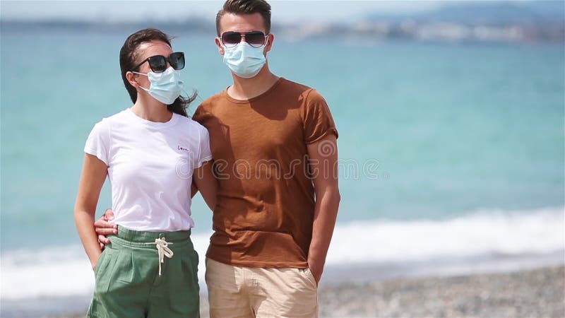 Unga par på vit strand under sommarsemestern
