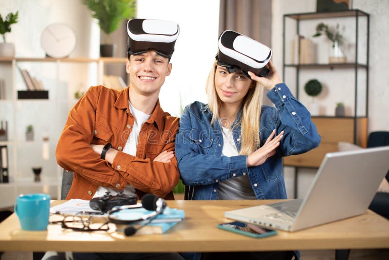 Unga par som använder vr headset och bärbar dator för att spela spel arkivfoton