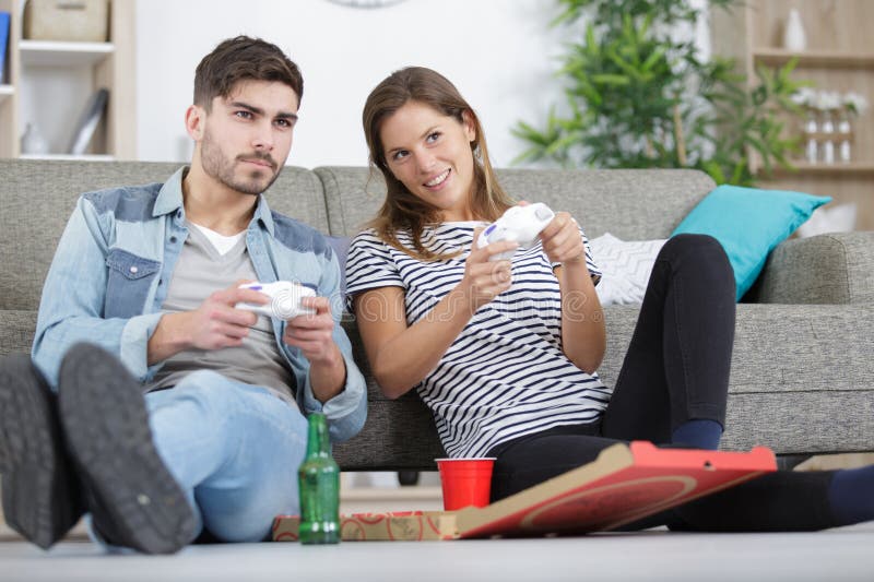 Unga par som spelar videospel hemma arkivfoto