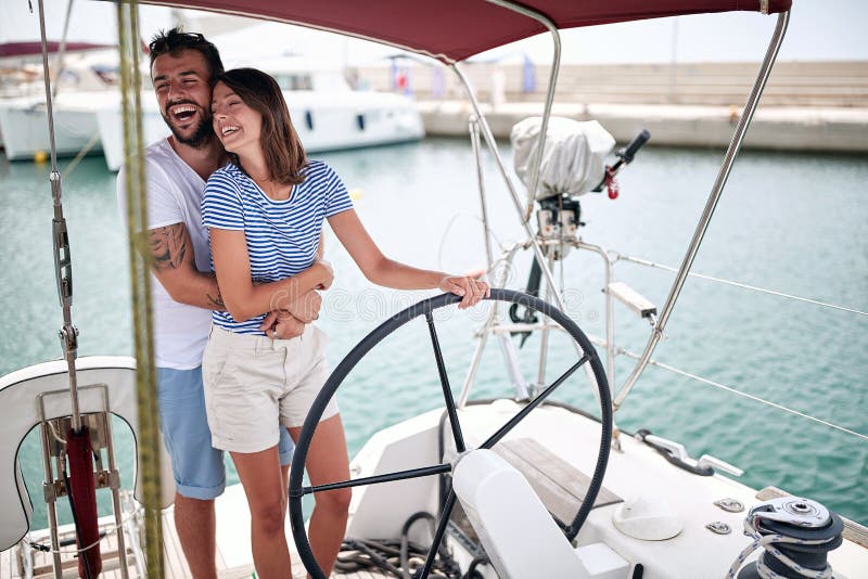Unga par tycker om att rida en yacht arkivfoton