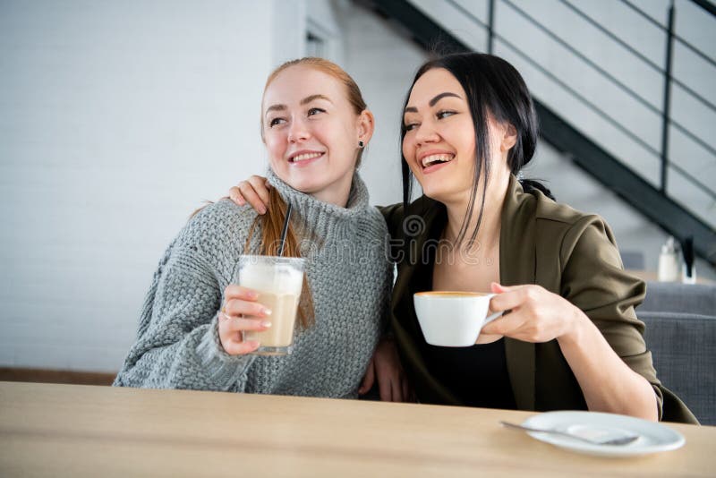 Unga två och härliga kvinnor möter på stången för en cappuccino och att prata royaltyfri fotografi Unga två och härliga kvinnor möter på stången för en cappuccino och att prata royaltyfri fotografi