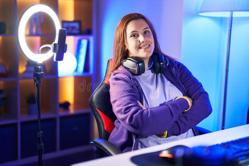 Unga, vackra och stora kvinnor smidigare och smildrade självsäkra sittande med en korsad gest på spelrummet arkivbild