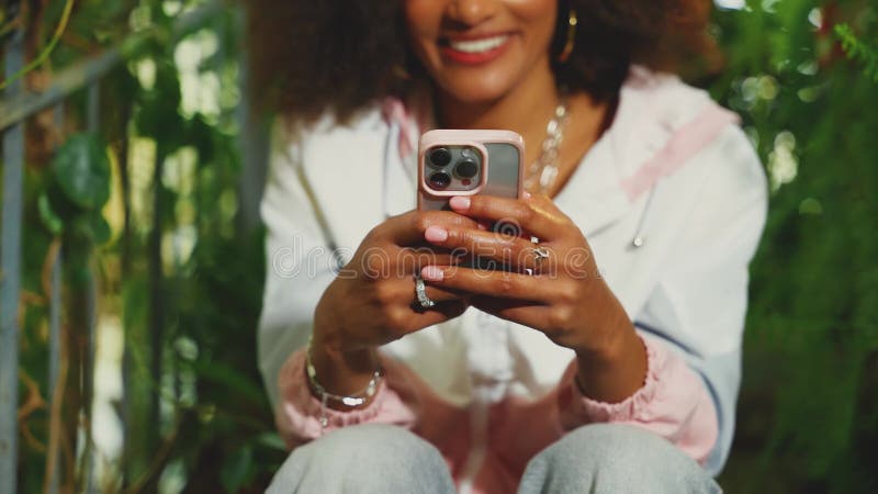 Unga vuxna, lyckliga afrikaner håller telefonen i händerna och läser nyhetsmeddelande kärlek på distans arkivfilmer