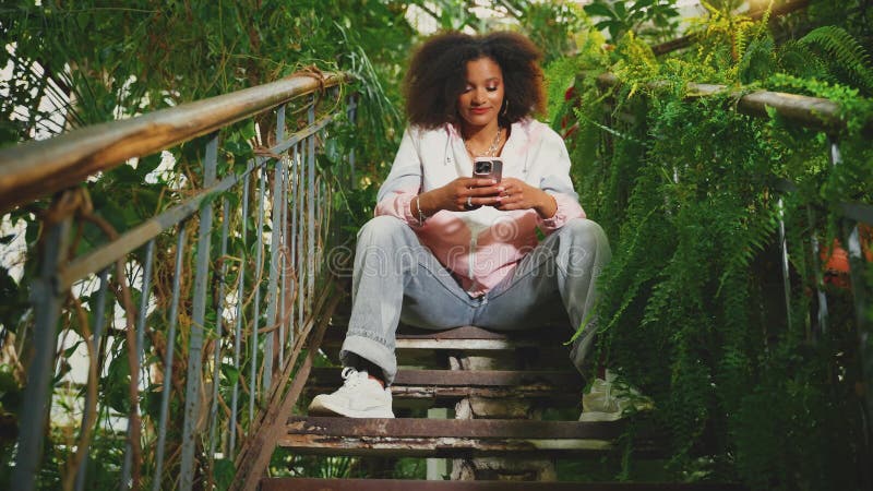 Unga vuxna, lyckliga afrikaner håller telefonen i händerna och läser nyhetsmeddelande kärlek på distans stock video