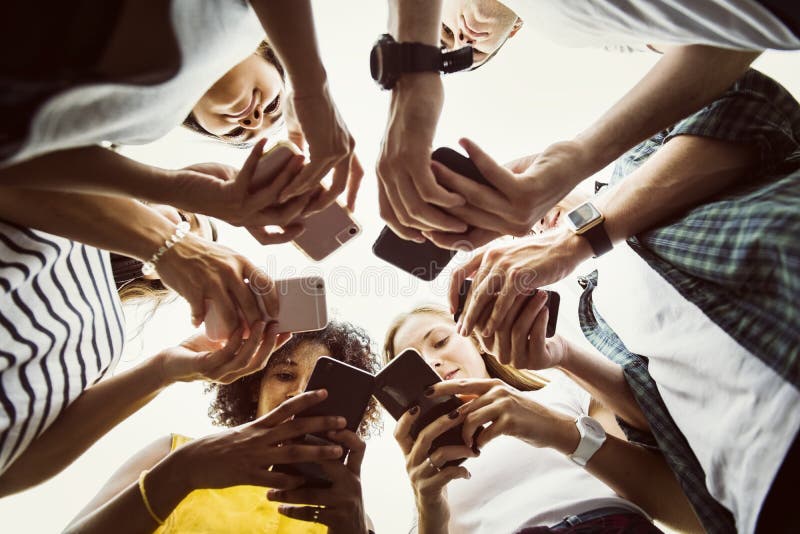 Young adults using smartphones in a circle social media and connection concept. Young adults using smartphones in a circle social media and connection concept