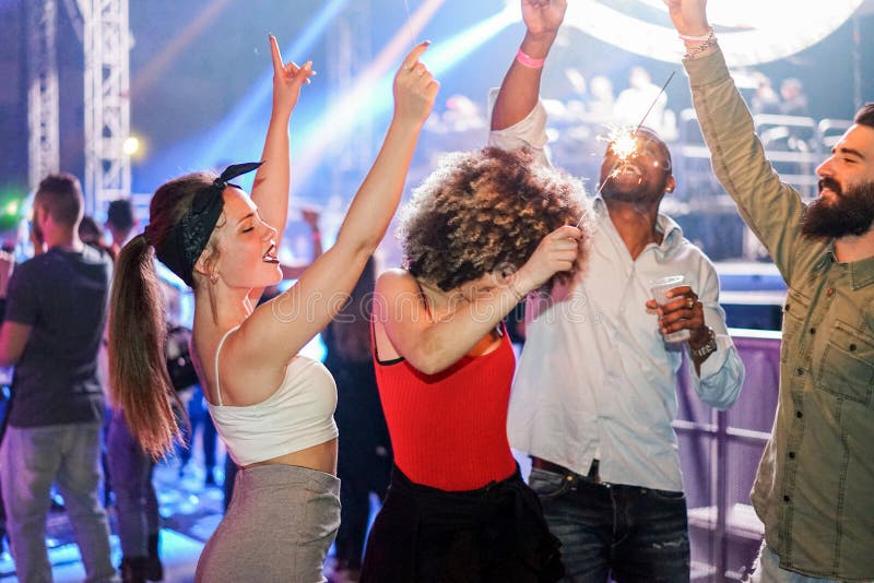 Unga vänner som dansar på nattklubbarnas festfest med dj i bakgrunden - Glade människor som har kul i disco - Nattliv