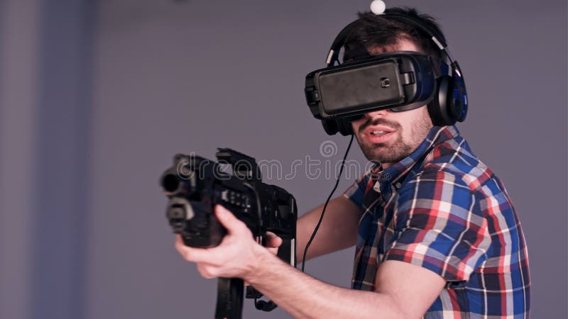 Unga vänner som spelar VR-prickskytten, spelar med virtuell verklighetvapen och exponeringsglas arkivbilder Unga vänner som spelar VR-prickskytten, spelar med virtuell verklighetvapen och exponeringsglas arkivbilder