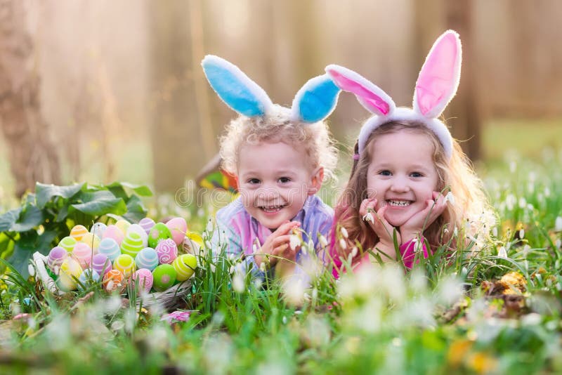 Ungar på jakt för påskägg i blommande vår arbeta i trädgården royaltyfria bilder Ungar på jakt för påskägg i blommande vår arbeta i trädgården royaltyfria bilder