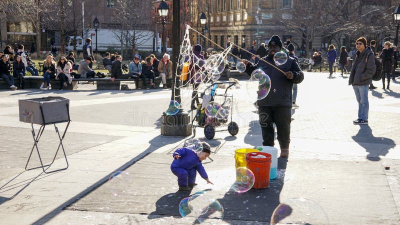 Ungar som har gyckel med slaget, bubblar i Manhattan, New York City royaltyfria bilder Ungar som har gyckel med slaget, bubblar i Manhattan, New York City royaltyfria bilder