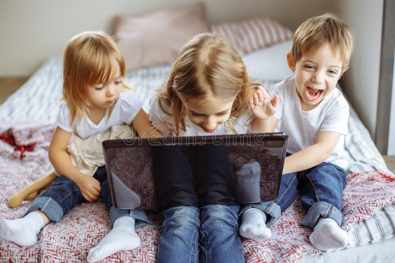 Ungar som hemma spelar med bärbar datordatoren arkivfoto Ungar som hemma spelar med bärbar datordatoren arkivfoto