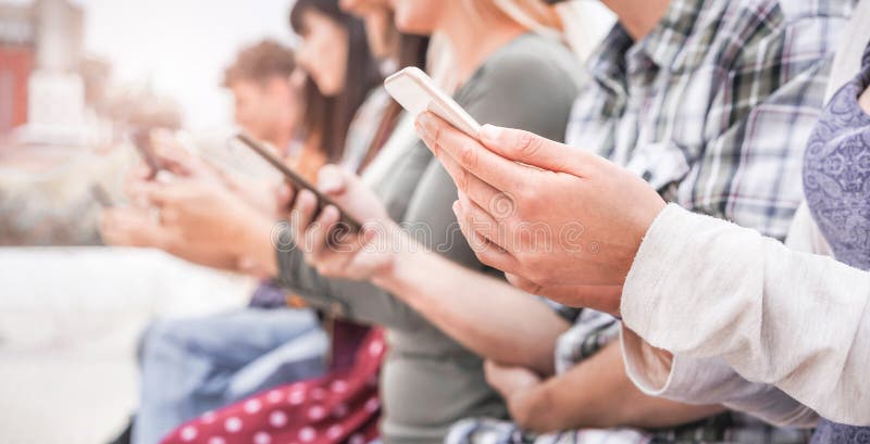 Ungdomar som använder smarta mobiltelefoner är beroende av nya tekniktrender inom den nya generationen unga år i år royaltyfri fotografi