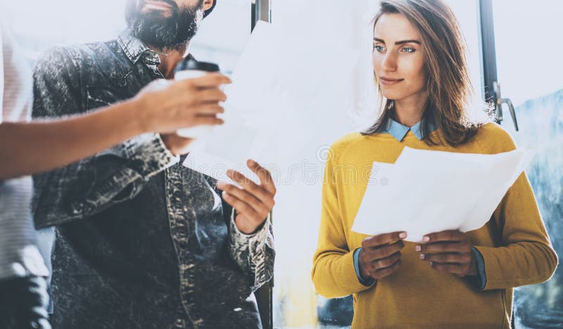 Ungdomarsom diskuterar affärsideasin ett kontor Man att rymma papperet hans händer och samtal med en kvinna horisontal arkivbild Ungdomarsom diskuterar affärsideasin ett kontor Man att rymma papperet hans händer och samtal med en kvinna horisontal arkivbild