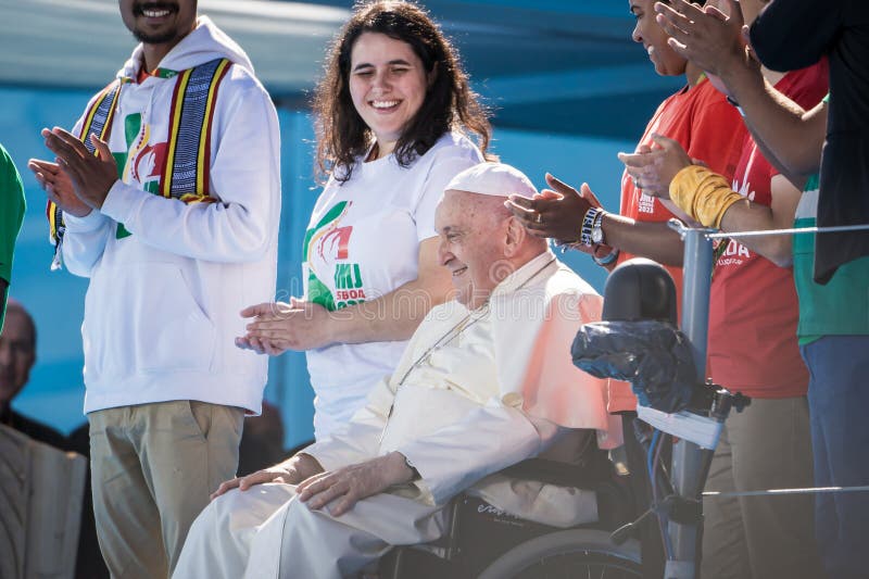 A smiling Pope Francis, surrounded by young people, greets those gathered at the papal altar in Edward VII Park during the welcome to World Youth Day 2023 in Lisbon. A smiling Pope Francis, surrounded by young people, greets those gathered at the papal altar in Edward VII Park during the welcome to World Youth Day 2023 in Lisbon.