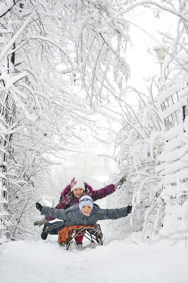 Kids sliding between trees in winter time. Kids sliding between trees in winter time