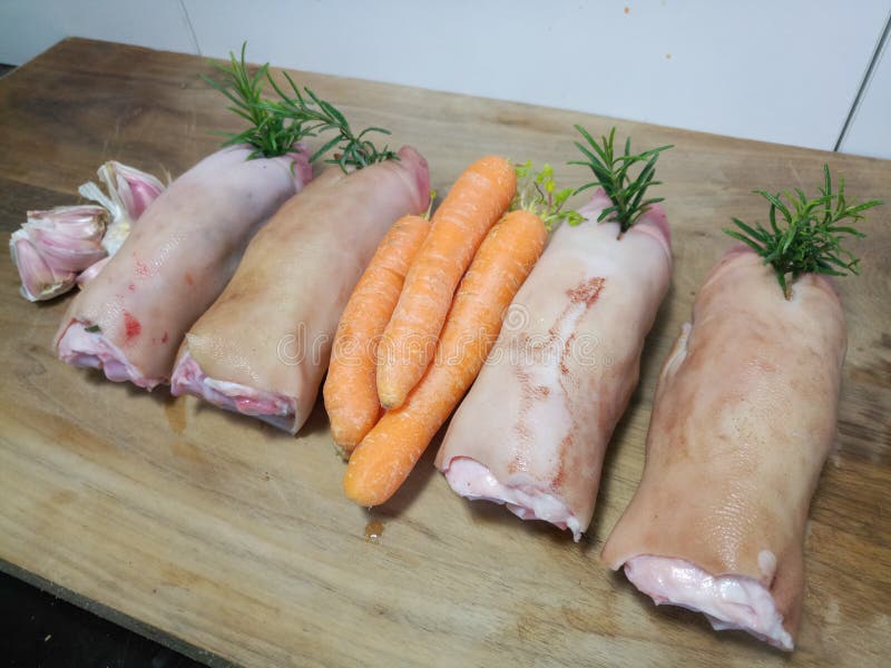 Ungekochte Schweinhufe mit Gemüse lizenzfreie stockbilder Ungekochte Schweinhufe mit Gemüse lizenzfreie stockbilder