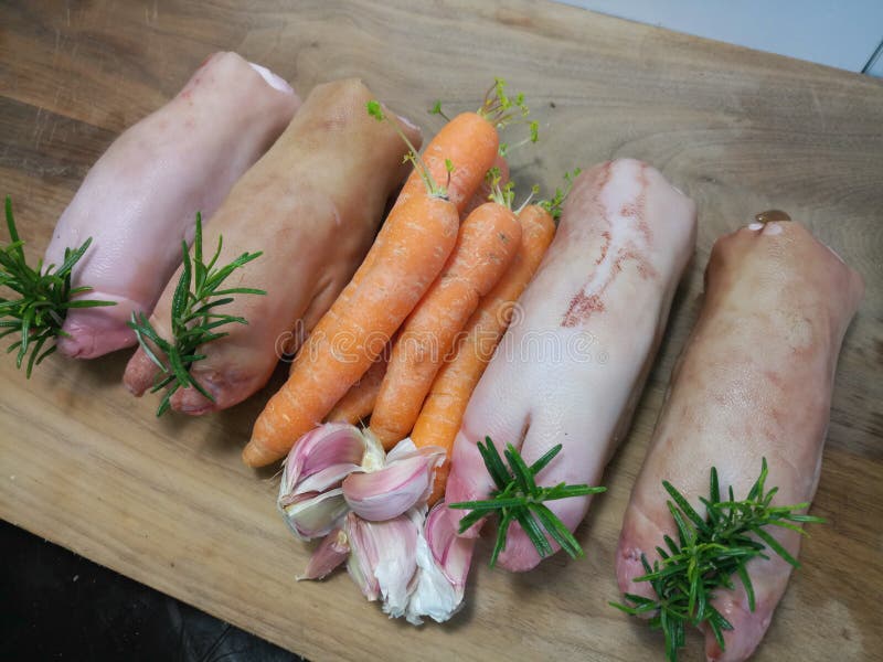 Ungekochte Schweinhufe und organische Karotten lizenzfreies stockfoto Ungekochte Schweinhufe und organische Karotten lizenzfreies stockfoto