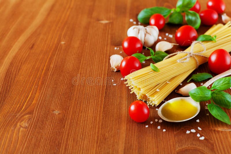 Ungekochte Spaghettis, Kirschtomate, Basilikum, Knoblauch und Olivenöl, Bestandteile für das Kochen von Teigwaren, Lebensmittelhi