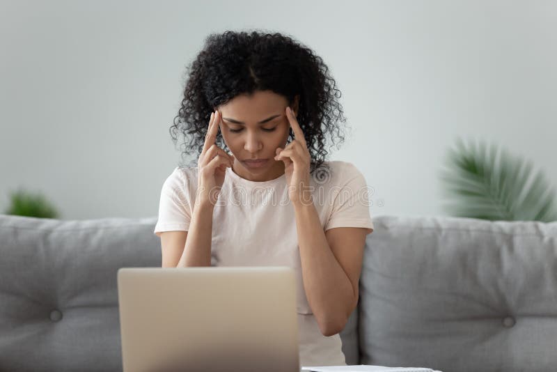 Ungesunde schwarze Frau mit Kopfschmerzen überfordert mit Computerarbeit