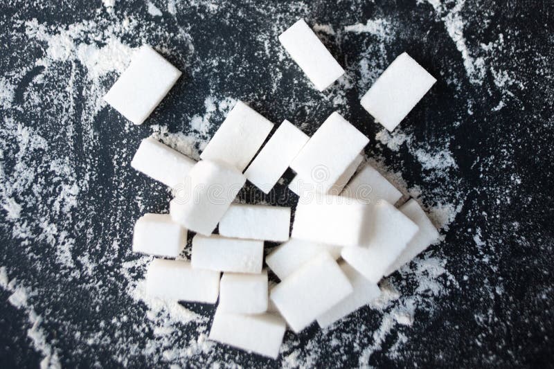 Ungesundes Lebensmittelkonzept - Zucker und Mehl auf einem schwarzen Hintergrund lizenzfreies stockbild Ungesundes Lebensmittelkonzept - Zucker und Mehl auf einem schwarzen Hintergrund lizenzfreies stockbild