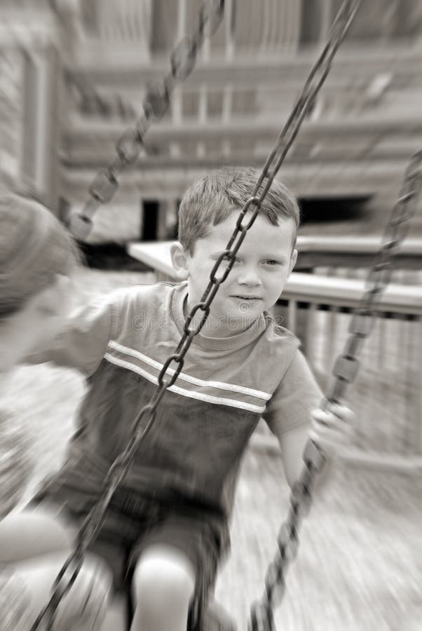 Young boy and girl on tire swing at park. Young boy and girl on tire swing at park