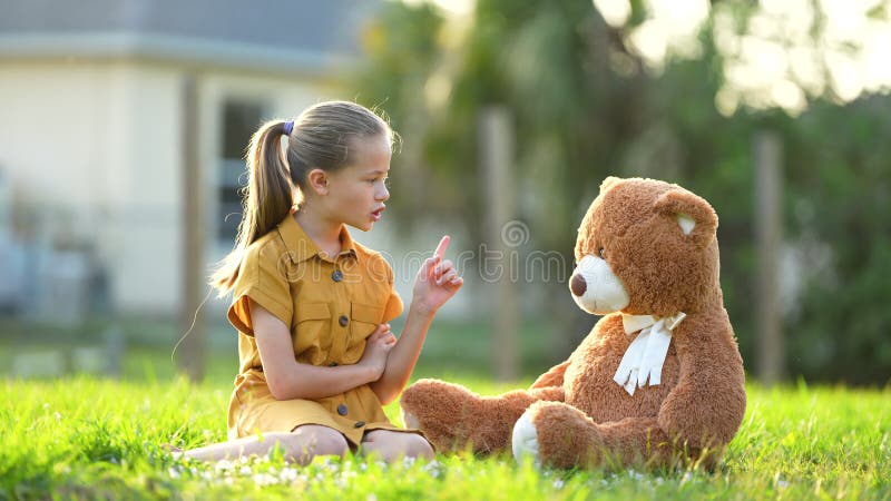 Unglückliche Teenager-Mädchen, die einen Streit mit dem Finger an ihrem Teddybär haben. Freundschaftsschwierigkeiten