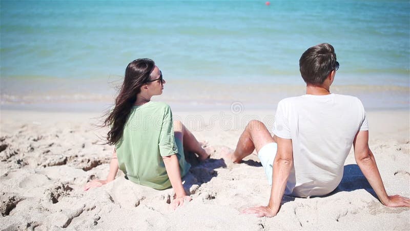 Ungt par på vit strand under sommarsemestern.