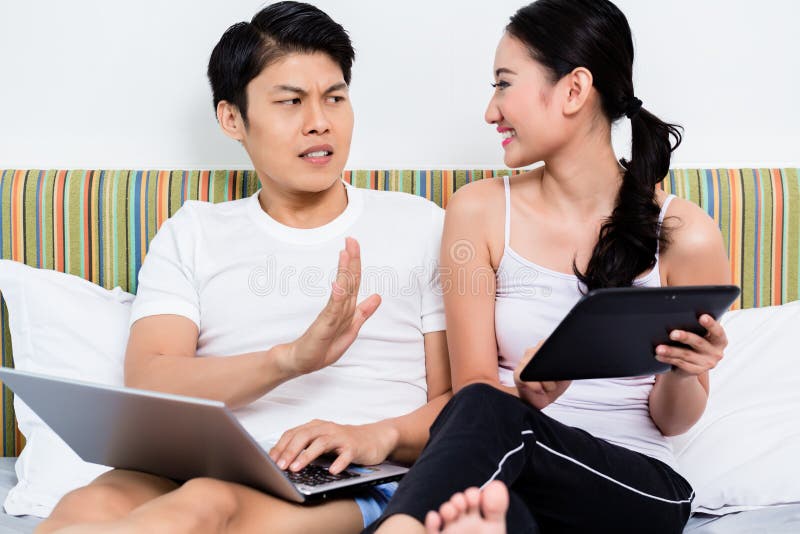 Unhappy Asian couple having issues surfing the internet royalty free stock image