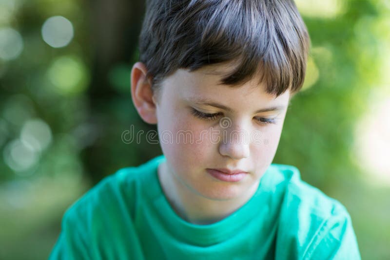 Close Up of Unhappy Boy Sitting Outdoors in Garden Stock Photo - Image ...