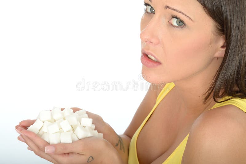 Unhappy Concerned Young Woman Holding a Handful of Unhealthy White Sugar Cubes stock photo Unhappy Concerned Young Woman Holding a Handful of Unhealthy White Sugar Cubes stock photo