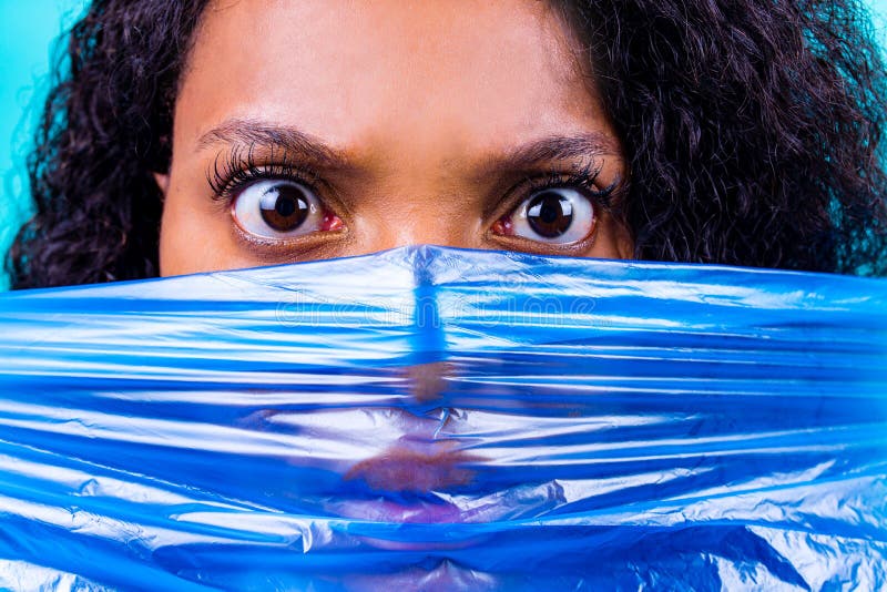 Unhappy Female with Plastic Bag on Her Head Against Blue Wall Studio