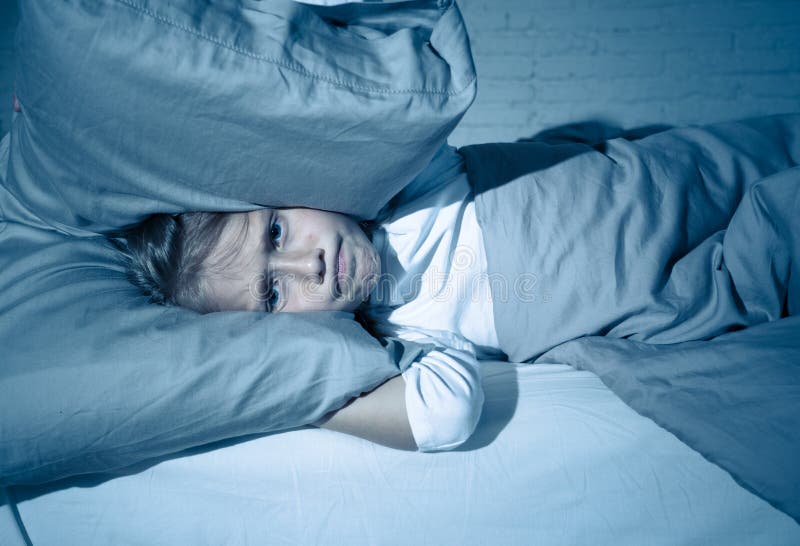Little girl having trouble sleeping at night holding pillow covering her head and ears upset royalty free stock photo Little girl having trouble sleeping at night holding pillow covering her head and ears upset royalty free stock photo