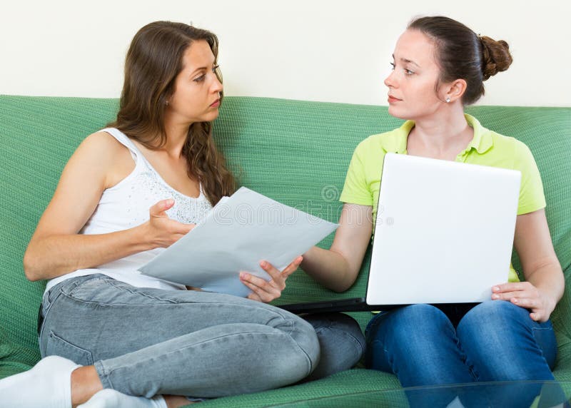 Unhappy girl looking business documents with laptop royalty free stock images Unhappy girl looking business documents with laptop royalty free stock images