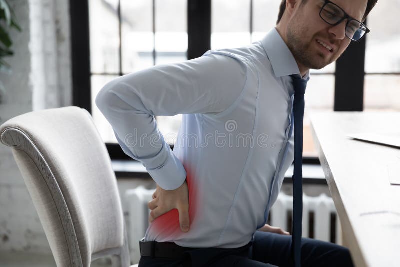 Unhappy office worker suffering from back pain attack