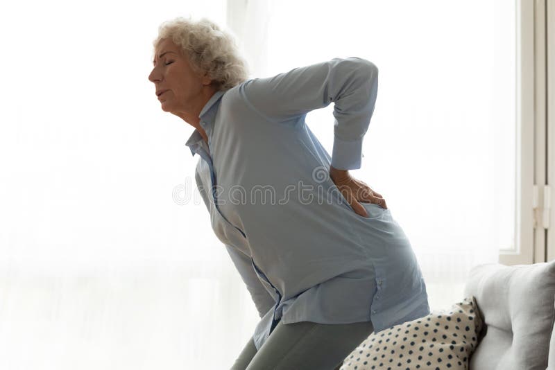 Unhappy older woman feeling pain, touching lower back