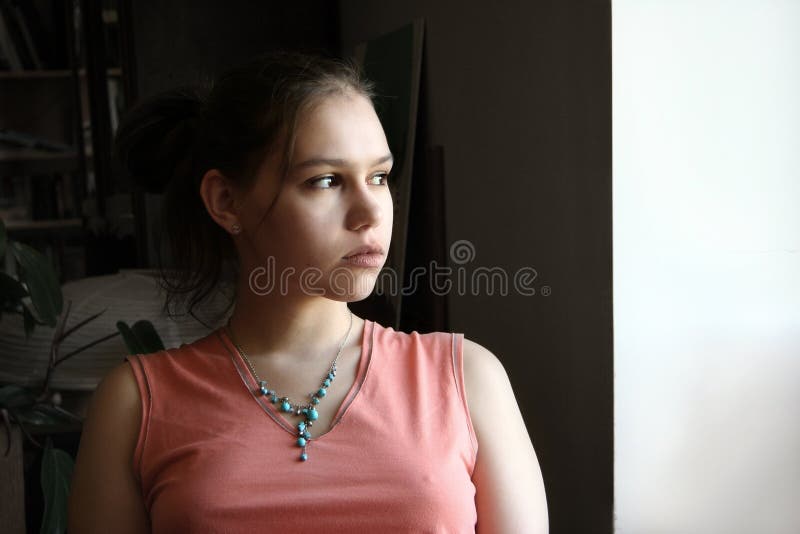 Nešťastný dospívající dívka u okna.