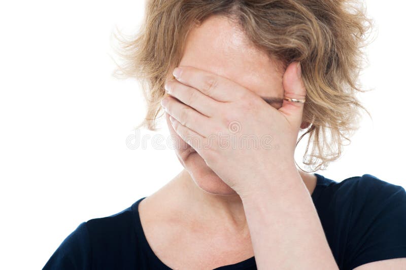 Unhappy woman hiding her face with hand on it royalty free stock photography