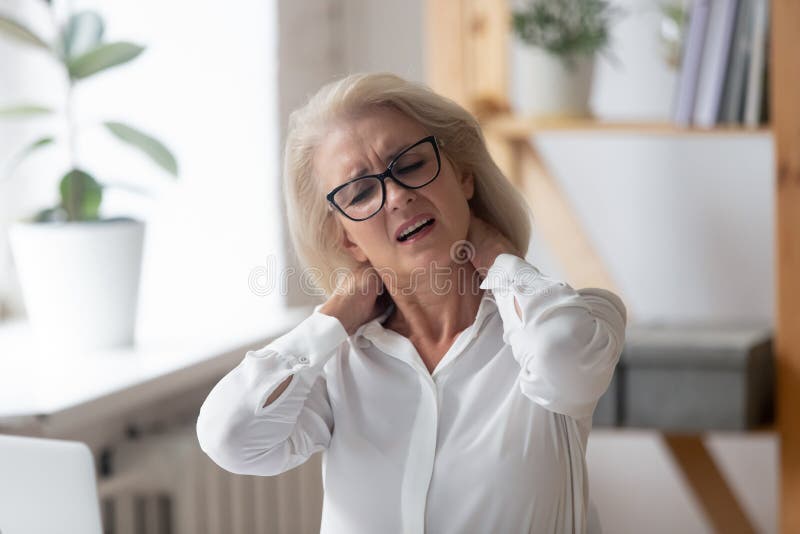 Unhappy 60 years old businesswoman massaging neck close up.