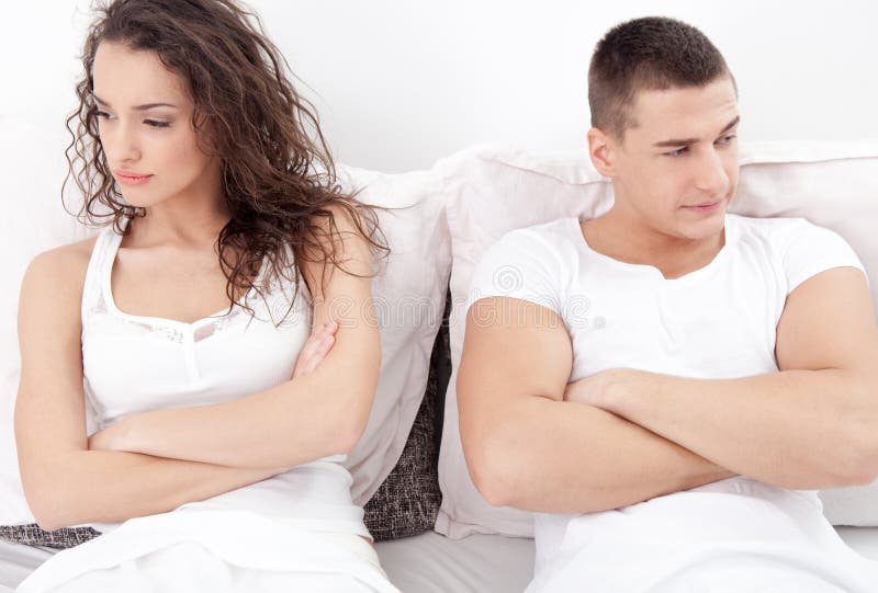 Unhappy young couple in bedroom under stress