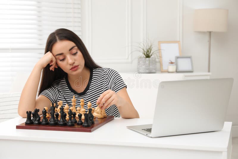 Premium Photo  Woman playing chess online uses laptop